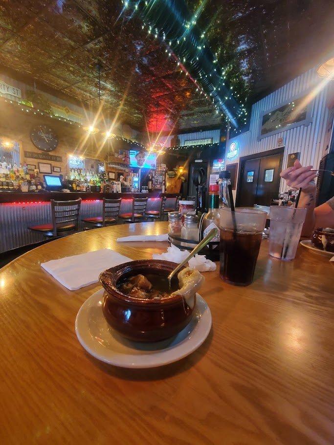 Pub interior with TVs, tables, and a bar counter.