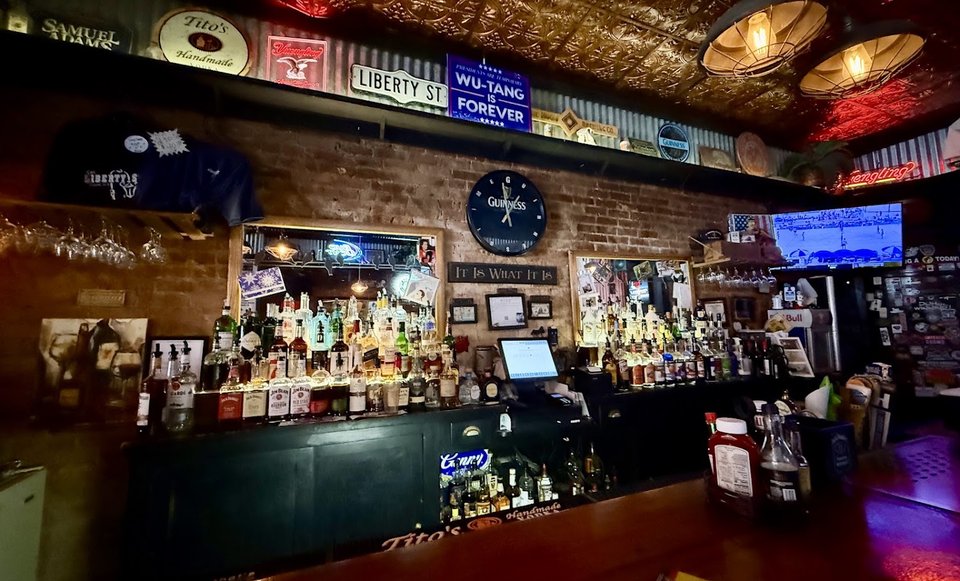 Simple restaurant seating beside a well-stocked bar.